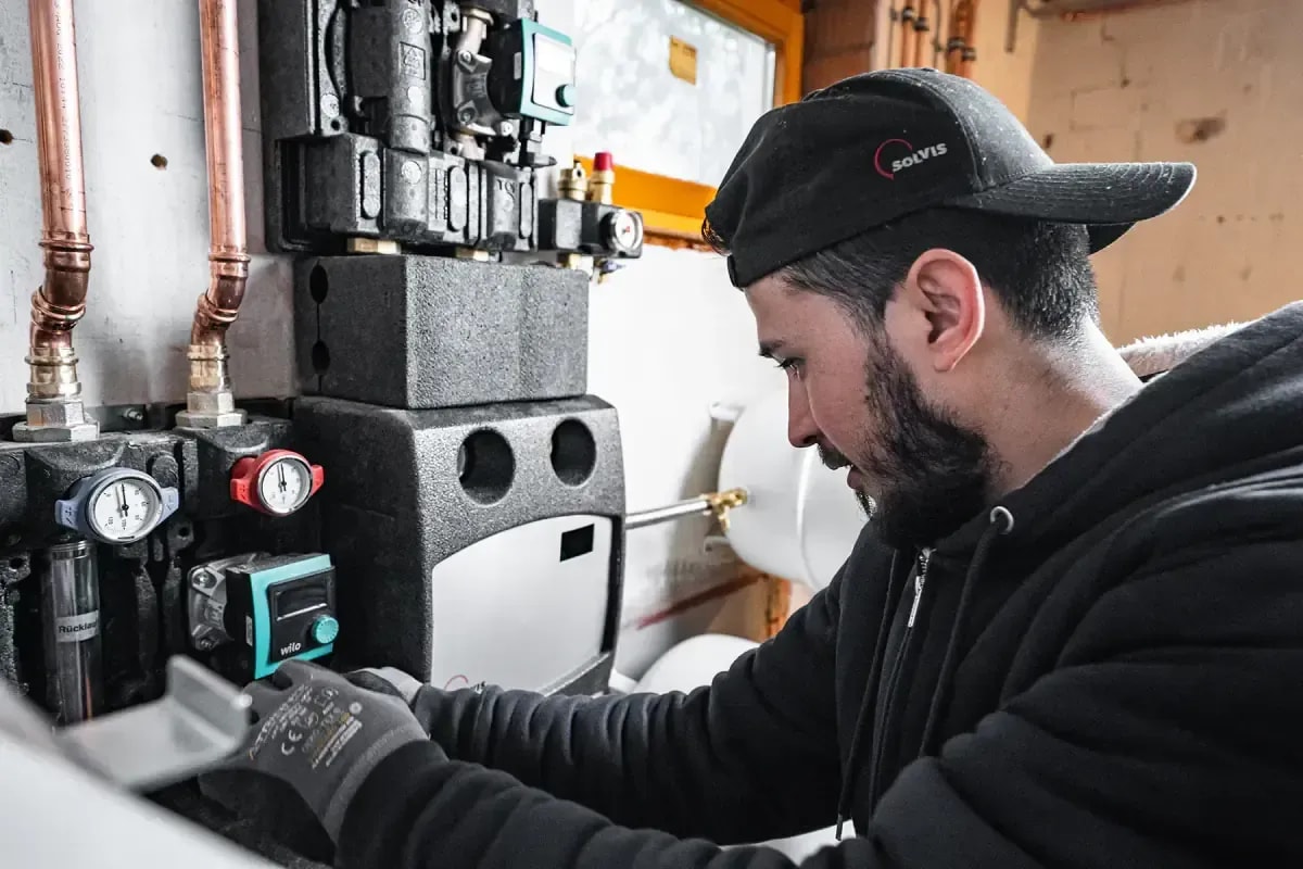 Techniker wartet moderne Heizungsanlage mit Wilo-Pumpe und Solvis-Heizsystem im Keller
